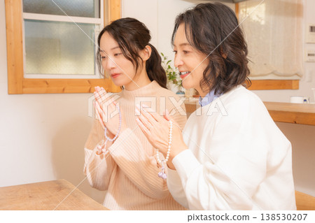 一對母女在家中為逝者祈禱。 一對母女在家中為逝者祈禱。 138530207