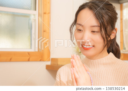 Daughter prays for the deceased at home. 138530214