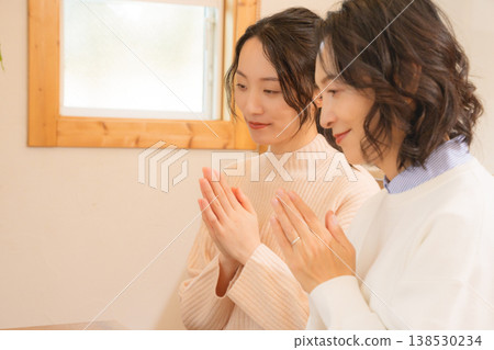一對母女在家中為逝者祈禱。 一對母女在家中為逝者祈禱。 138530234