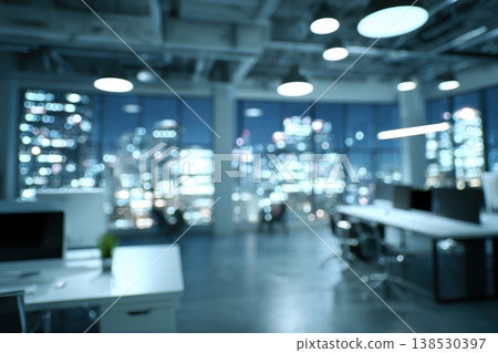 Modern coworking space at night with glowing city lights visible through large windows Modern coworking space at night with glowing city lights visible through large windows 138530397