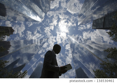 Looking Up Vertically From the Base of a Single Tower Under Bright Clouds and Sunlight Looking Up Vertically From the Base of a Single Tower Under Bright Clouds and Sunlight 138530461