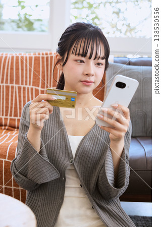使用智慧型手機進行線上支付的女性 使用智慧型手機進行線上支付的女性 138530556