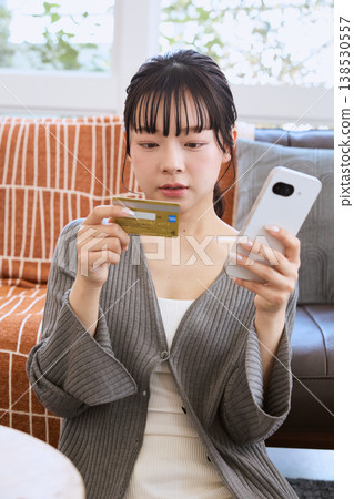 使用智慧型手機進行線上支付的女性 使用智慧型手機進行線上支付的女性 138530557