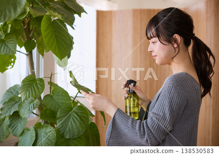 A young woman tending to houseplants A young woman tending to houseplants 138530583