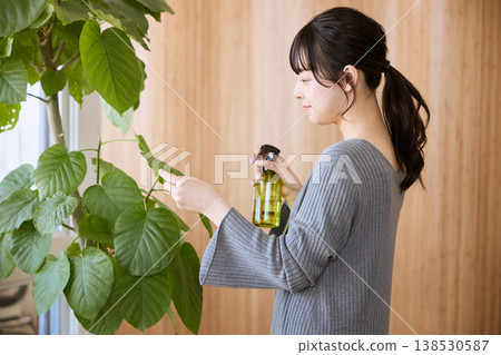 一位年輕女子正在照顧室內植物 一位年輕女子正在照顧室內植物 138530587