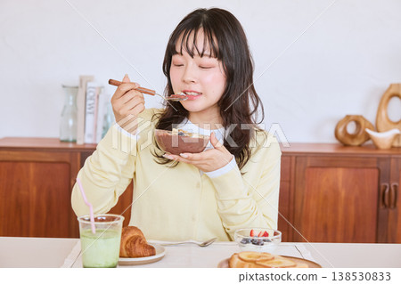 A young woman eating an acai bowl for breakfast. 138530833