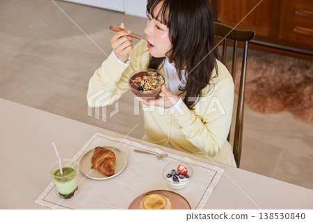 一位年輕女子正在享用一碗健康的巴西莓早餐。 138530840