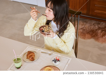 一位年輕女子正在享用一碗健康的巴西莓早餐。 138530841