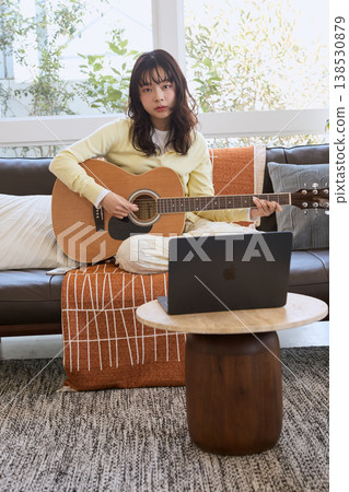 一位女士在線練習吉他 一位女士在線練習吉他 138530879