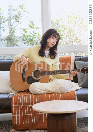 一位女性的生活方式,她以彈吉他為愛好。 一位女性的生活方式,她以彈吉他為愛好。 138530886