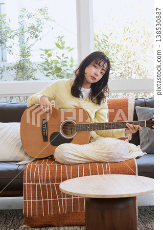 一位女性的生活方式,她以彈吉他為愛好。 一位女性的生活方式,她以彈吉他為愛好。 138530887