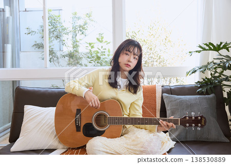 一位女性的生活方式,她以彈吉他為愛好。 一位女性的生活方式,她以彈吉他為愛好。 138530889