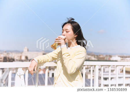 A young woman enjoying a beer under the blue sky 138530899