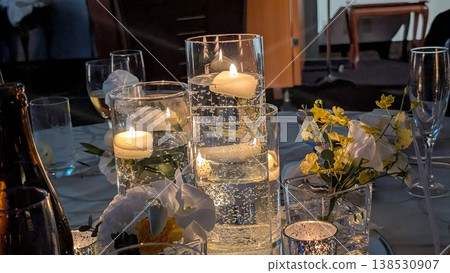 A scene of a wedding reception table with candles lit. 138530907