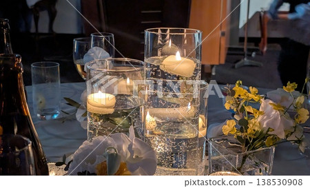 A scene of a wedding reception table with candles lit. 138530908