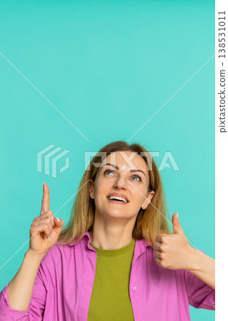 Woman pointing up with serious expression drawing attention to important thing or key information 138531011