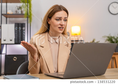 Businesswoman watches laptop sales drop frowns shrugs why news negative trend graph red arrow down Businesswoman watches laptop sales drop frowns shrugs why news negative trend graph red arrow down 138531220