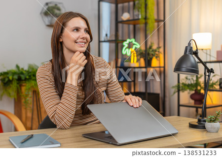 Young woman closes laptop with relief smiles as project is sent and work finished milestone reached 138531233