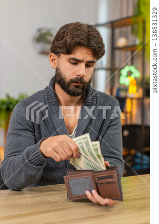 Indian man opens wallet finds small dollar cash unhappy budget worry debt low income poverty sad low 138531329