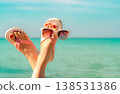 Upside woman feet and red pedicure wearing pink sandals, sunglasses at seaside. Funny and happy fashion young woman relax on vacation. Chill out girl at beach. Creative for tour agent. Weekend travel. Upside woman feet and red pedicure wearing pink sandals, sunglasses at seaside. Funny and happy fashion young woman relax on vacation. Chill out girl at beach. Creative for tour agent. Weekend travel. 138531386