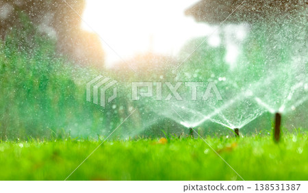 Automatic lawn sprinkler watering green grass. Sprinkler with automatic system. Garden irrigation system watering lawn. Water saving or water conservation from sprinkler system with adjustable head. Automatic lawn sprinkler watering green grass. Sprinkler with automatic system. Garden irrigation system watering lawn. Water saving or water conservation from sprinkler system with adjustable head. 138531387