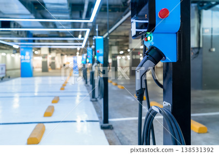 Electric car charging station for charge EV battery. Plug for vehicle with electric engine. EV charger. Clean energy. Charging point at car parking lot. Green power. Future transport technology. 138531392