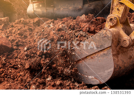 Closeup bucket of backhoe digging the soil at construction site. Crawler excavator digging on demolition site. Excavating machine. Earth moving equipment. Excavation vehicle. Construction business. 138531393