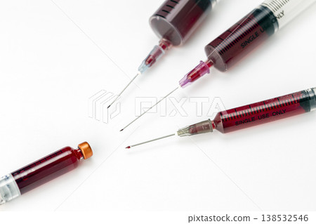 Close-Up of Multiple Medical Syringes Filled With Dark Red Blood Samples and Sharp Needles Arranged on a Clean White Background for Healthcare Concepts Close-Up of Multiple Medical Syringes Filled With Dark Red Blood Samples and Sharp Needles Arranged on a Clean White Background for Healthcare Concepts 138532546
