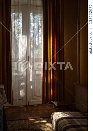 Natural sunlight streaming through a window with white curtains into a retro room. Soft glow 138532672