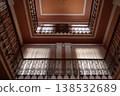 Two-story building atrium with wrought iron railings and high windows.  138532689