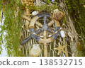 Decorative ship steering wheel with shells and a fishing net.  138532715