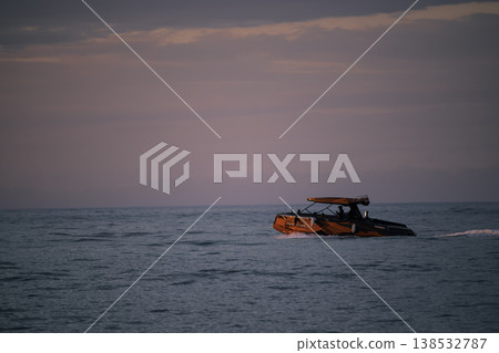 Red motorboat cruising on calm sea under soft pastel sunset sky, modern speed boat on open water with copy space, evening marine travel and leisure concept, minimal seascape composition Red motorboat cruising on calm sea under soft pastel sunset sky, modern speed boat on open water with copy space, evening marine travel and leisure concept, minimal seascape composition 138532787