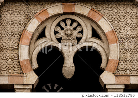 Ornamental stone arch with intricate geometric patterns and decorative relief, historic architecture detail with symmetry and textured facade, classic design element with cultural motif Ornamental stone arch with intricate geometric patterns and decorative relief, historic architecture detail with symmetry and textured facade, classic design element with cultural motif 138532796