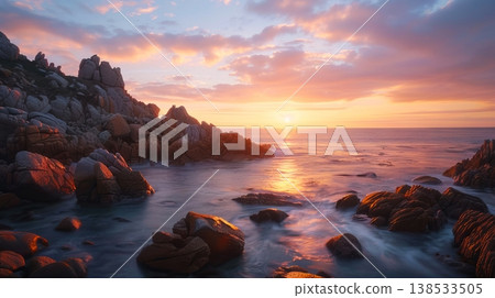 Tranquil rocky shoreline at sunset with vibrant sky Tranquil rocky shoreline at sunset with vibrant sky 138533505