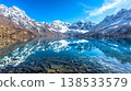 Clear Mountain Lake Reflecting Towering Snow-Capped Peaks on a Bright Day, Concept of Natural Beauty, Outdoor Adventure, Tranquility in Nature, and Scenic Landscapes 138533579