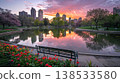 City Park at Sunset with a Pond Reflecting Vibrant Colors and Spring Blossoms Near Urban Skyline 138533580