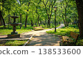 Tranquil City Park Scene with Fountain and Benches Amid Lush Greenery. Concept of Urban Oasis, Nature, Serene Retreat, and Outdoor Relaxation 138533600