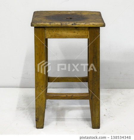 Rustic wooden stool stands proudly in a minimalist setting highlighting the beauty of craftsmanship and simplicity in design Rustic wooden stool stands proudly in a minimalist setting highlighting the beauty of craftsmanship and simplicity in design 138534348