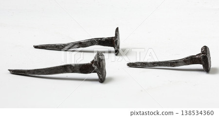 Rustic nails showcase the beauty of handcrafted metalwork in an artisan's workshop setting 138534360