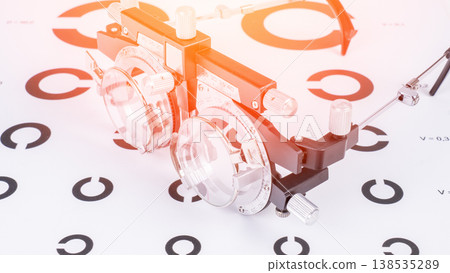Optometric device rests on eye chart Optometric device rests on eye chart 138535289