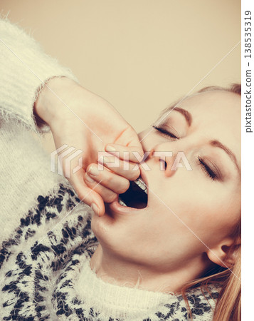 Sleepy yawning teenage woman in jumper 138535319