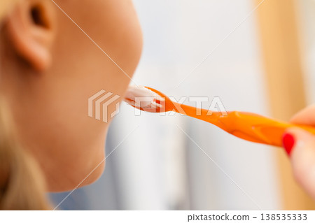 Woman brushing her teeth Woman brushing her teeth 138535333