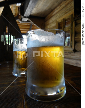 Two beer glasses on the old wooden table in country restaurant  138535440
