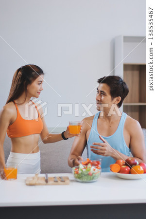 A happy couple prepares fresh vegetables, laughing and enjoying cooking a healthy meal together. A happy couple prepares fresh vegetables, laughing and enjoying cooking a healthy meal together. 138535467