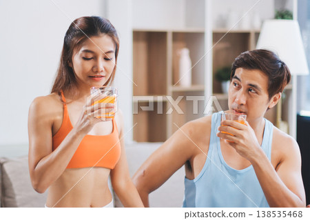 A happy couple prepares fresh vegetables, laughing and enjoying cooking a healthy meal together. 138535468