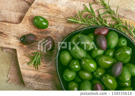 Chalkidiki olives, classic Greek green olives, in a bowl on a cutting board, top view, without people, Chalkidiki olives, classic Greek green olives, in a bowl on a cutting board, top view, without people, 138535618