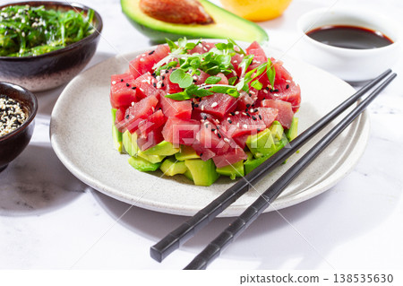 Fresh tuna tartare with avocado served on a marble table with soy sauce and seaweed salad Fresh tuna tartare with avocado served on a marble table with soy sauce and seaweed salad 138535630