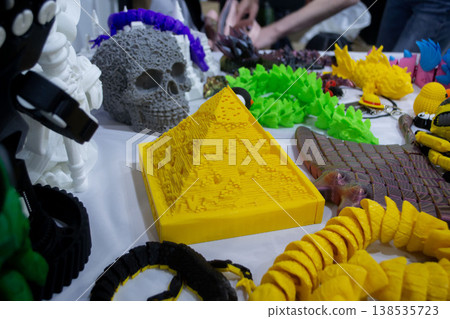 3D printed different art objects. Objects printed on 3D printer from melted colored plastic. Model yellow pyramid created on 3D printer from threads of molten plastic. Modern additive technologies 3D printed different art objects. Objects printed on 3D printer from melted colored plastic. Model yellow pyramid created on 3D printer from threads of molten plastic. Modern additive technologies 138535723
