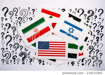 National flags of United States, Israel, Iran, and Lebanon lie scattered over paper with question marks. Global security uncertainty, future of international relations, complex political questions. 138535865