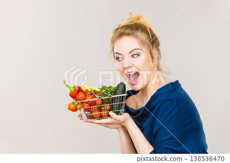 Woman holds shopping basket with vegetables Woman holds shopping basket with vegetables 138536470